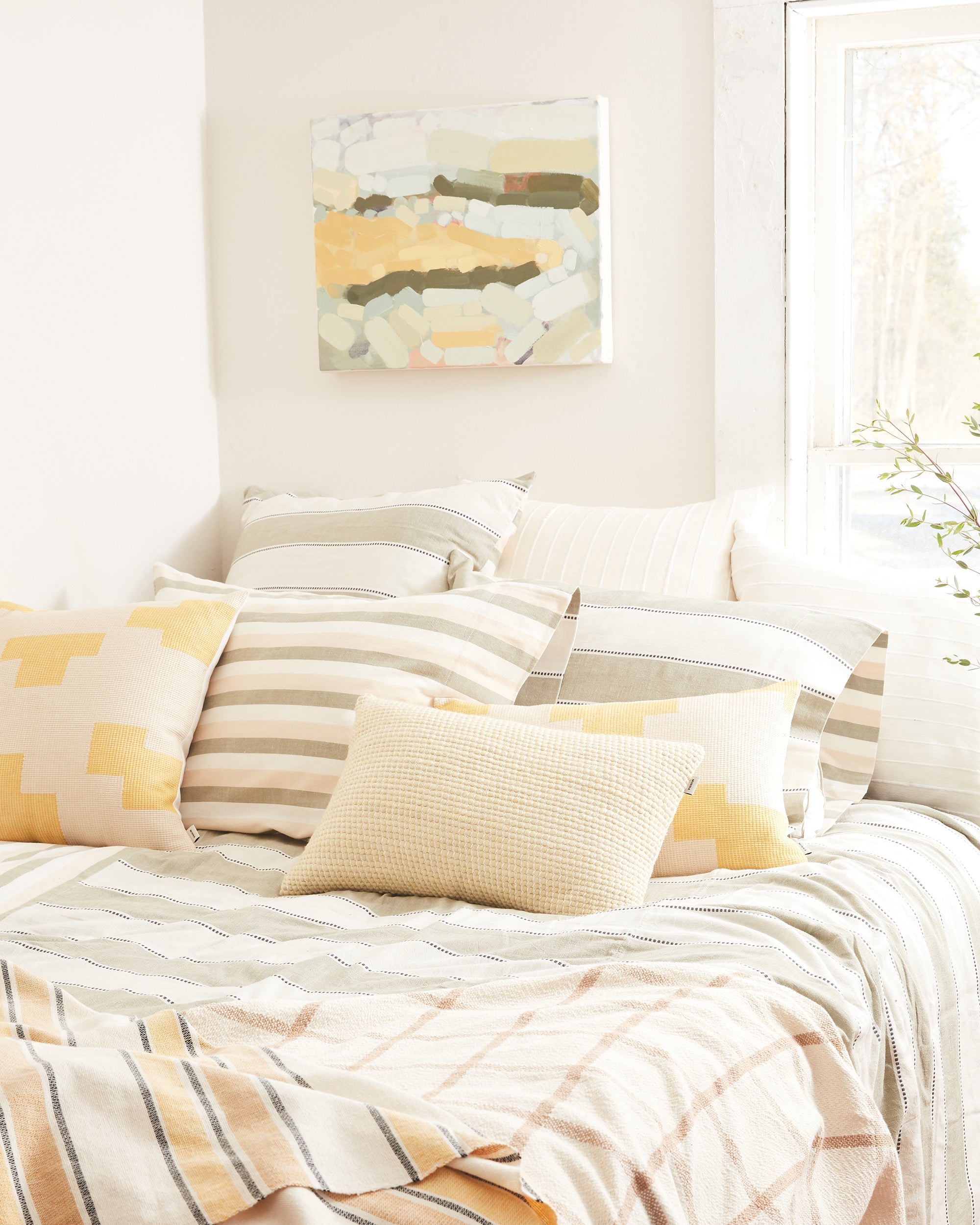 Bright bedroom with ethically handwoven oeko-tex cotton bedding designed by MINNA in sage neutral stripes