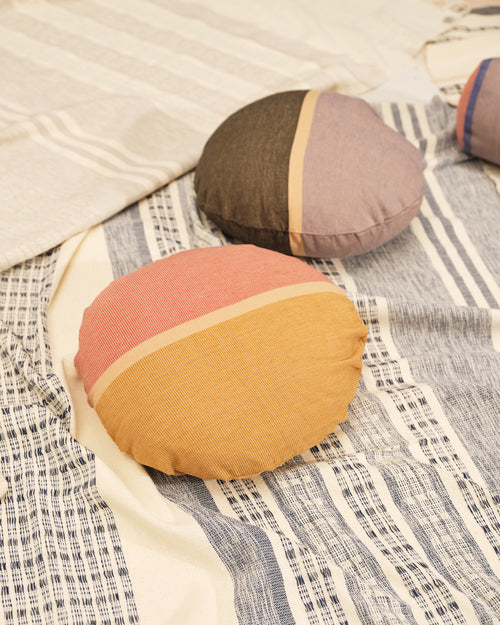 Textural ethically handwoven MINNA stripe blanket with circular round pillows in yellow, peach, hunter green, lavender